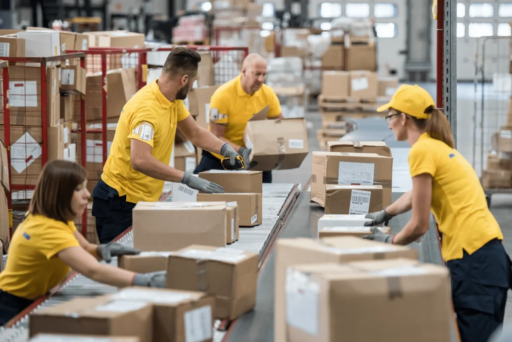 Temporary Staffing 8 warehouse workers working beside a converyor belt