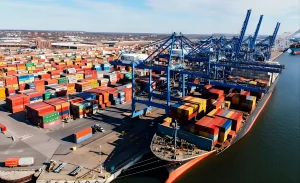 A busy US shipping port featuring stacked colorful containers, highlighting the demand for professional lumping services in the US to manage high-volume freight.