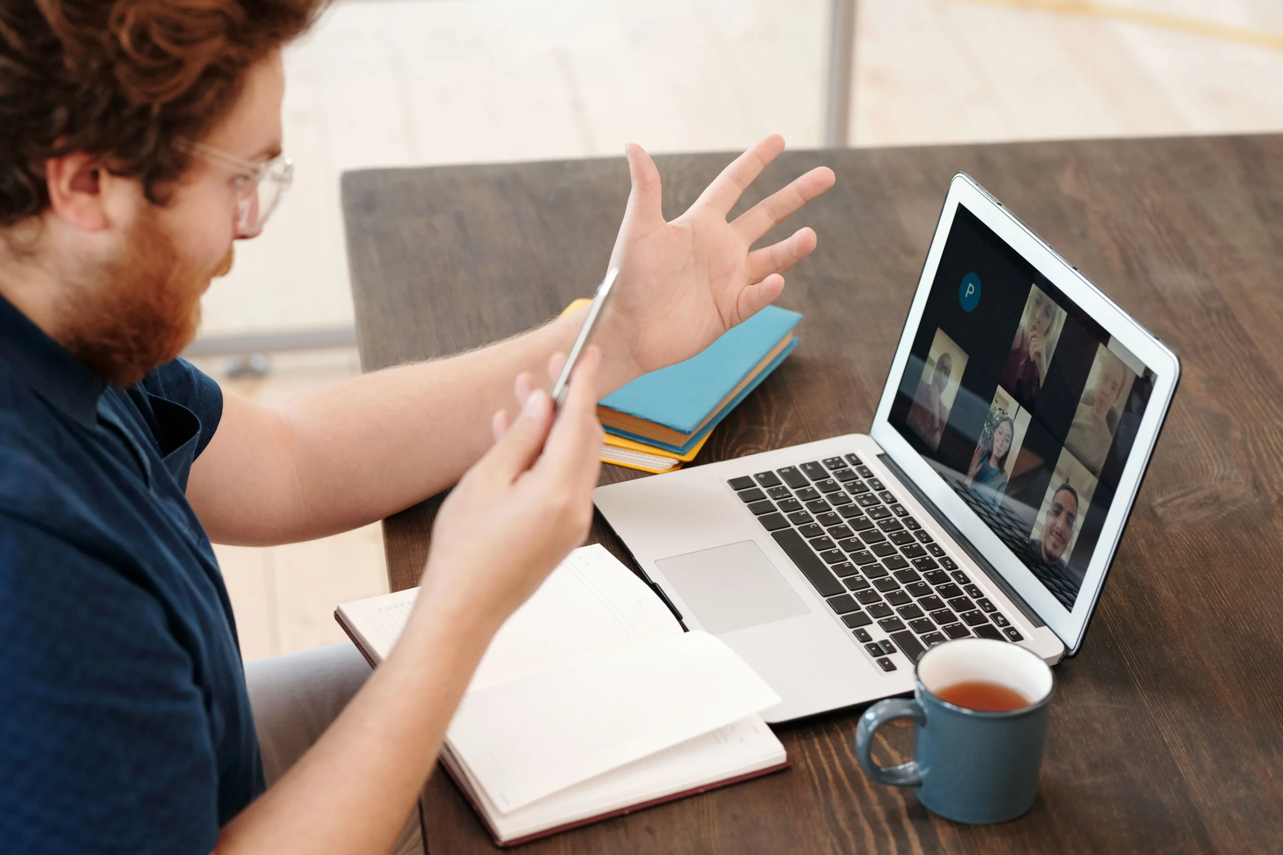 Key Positions You Can Hire Remotely in the Philippines and Morocco 1 A business owner sitting at his desk, leading a virtual video meeting with his remote team acquired via BPO services.